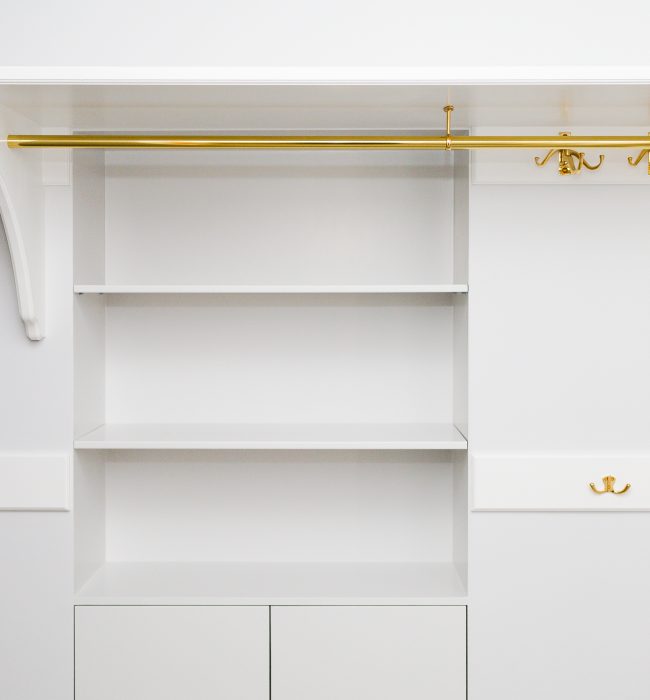 Förvaring i vitt med mässing detaljer i en walk in closet