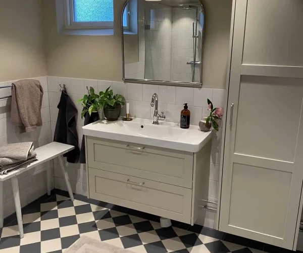 Badrumsrenovering i Täby i 50-tals design med svart och vitt kakel