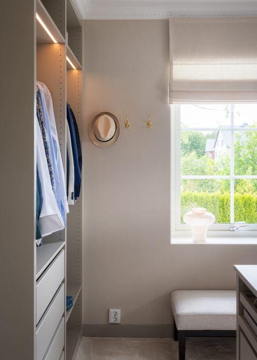 En totalrenovering i stockholm där en walk in closet har byggts med en garderob med många fack utan garderobsdörr