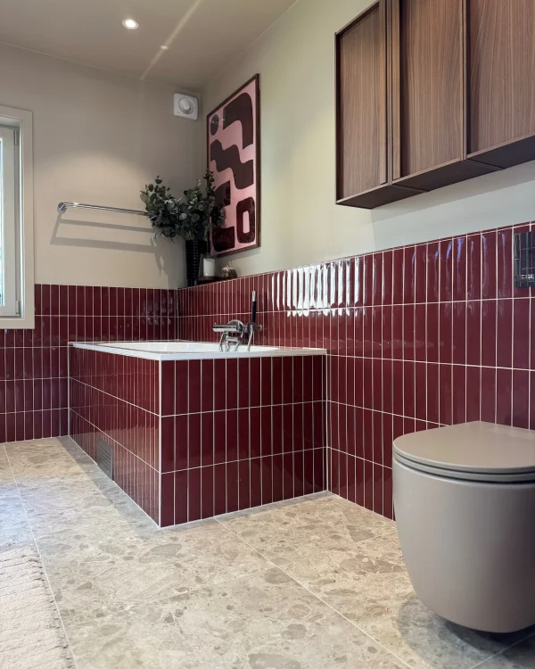 Badrumsrenovering i Stockholm med rött kakel, badkar och toalett